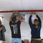 Dan and Michelle hanging the Why/Why Not Vegan Poster
