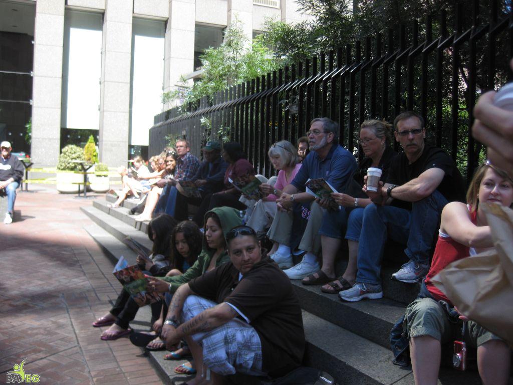 Waiting for the parade and reading a VSK from pre-parade leafleting by Ann, Katherine, Mila, Reeba and Tammy