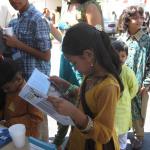 Young reader of PETA's All Animals are Equal at BAVeg booth at the JCNC 10th Anniversary celebration