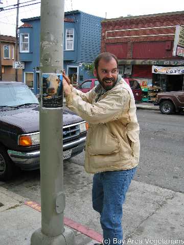 Warren putting up Peaceable Kingdom Posters - July 04
